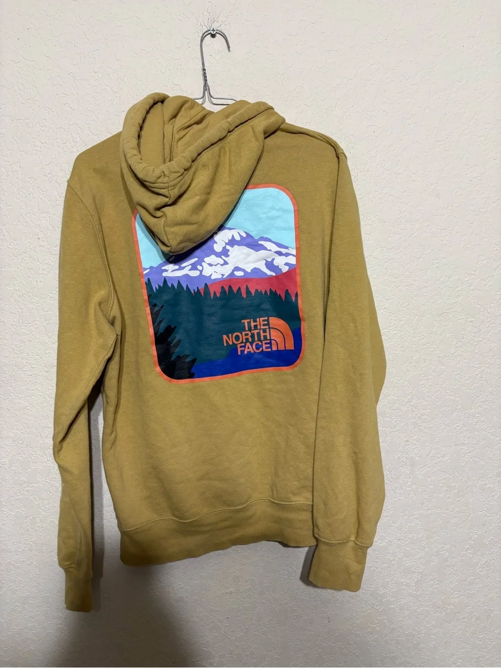 The North Face Mustard Pullover Hoodie with mountain outdoors scenery